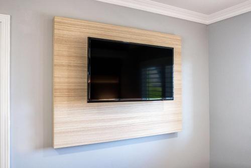 a flat screen tv on a wall at Travelodge Inn & Suites by Wyndham Bell Los Angeles Area in Bell