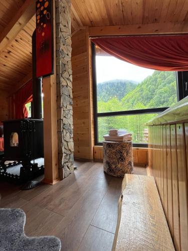 a living room with a fireplace and a large window at Ayder Paradise Otel in Ayder Yaylasi