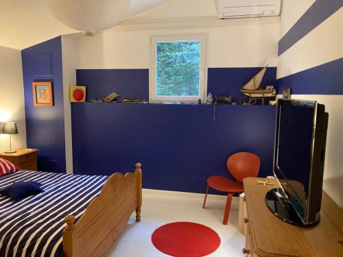 a bedroom with a bed and a blue wall at Chez Muriel et Jef in Graulet