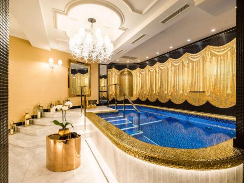 a hotel lobby with a pool and a chandelier at Bachleda Luxury Hotel Krakow MGallery Hotel Collection in Kraków
