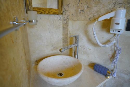 Baño sucio con lavabo y espejo en Vezir Cave Suites, en Göreme