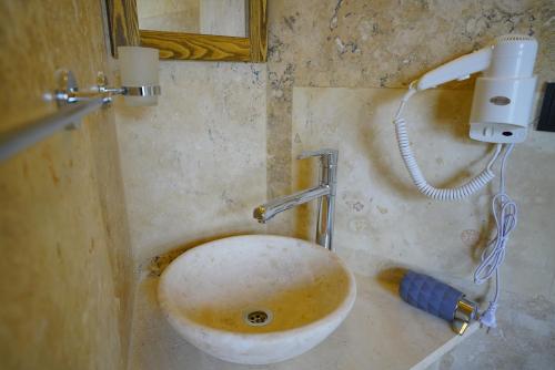 a dirty bathroom with a sink and a mirror at Vezir Cave Suites in Goreme