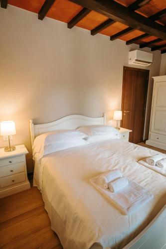 a bedroom with a white bed with two towels on it at Borgo Il Poggiaccio Residenza d'Epoca in Sovicille