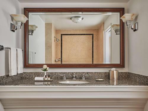 a bathroom with a sink and a large mirror at Fairmont Miramar Hotel & Bungalows in Los Angeles