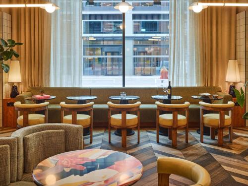 un ristorante con tavoli e sedie e una finestra di TRIBE London Canary Wharf a Londra