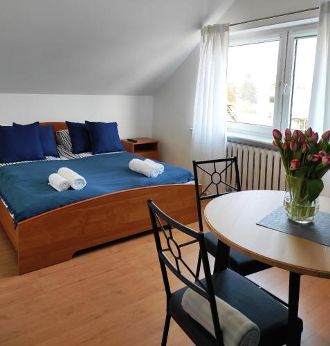 a bedroom with a bed and a table and chairs at Willa MEWA in Jastarnia