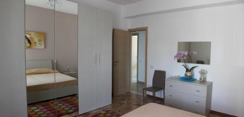 Schlafzimmer mit einem Bett, einer Kommode und einem Spiegel in der Unterkunft Casa Vacanze La Perla in Matera