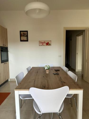 a large wooden table with white chairs in a room at Chiaro di Luna Guest House in Roccella Ionica