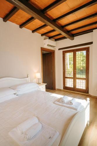 a bedroom with a large white bed with towels on it at Borgo Il Poggiaccio Residenza d'Epoca in Sovicille