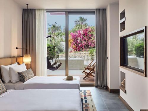 a hotel room with two beds and a large window at Hyde Bodrum - Adult Only in Bodrum City