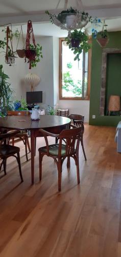 un salon avec une table et des chaises en bois dans l'établissement maison cretoise, à Crest