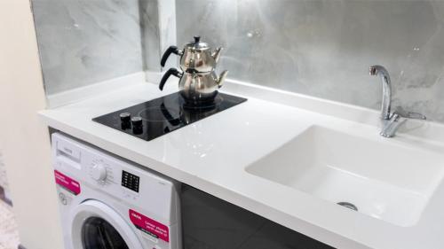 a kitchen with a washing machine and a sink at ELEGANCE SİRİUS in Kayseri