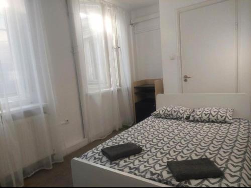 1 dormitorio con 1 cama blanca y 2 almohadas negras en Apart Lwowska, en Varsovia