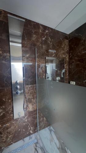 a bathroom with a glass shower with a mirror at Hôtel Séjour D'Ardenne in Spa