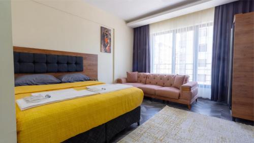 sypialnia z dużym żółtym łóżkiem i kanapą w obiekcie ELEGANCE SİRİUS w mieście Balqash