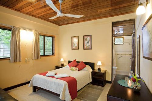 a bedroom with a large bed and a bathroom at Hotel Jaguar Inn Tikal in Tikal