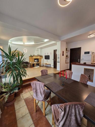 a dining room with a table and chairs and a living room at Pensiunea Eliza in Sinaia