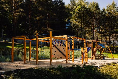 a playground in a park with a play structure at Między Drzewami in Olsztyn