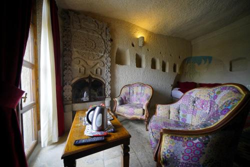 a room with two chairs and a table and a bed at Vezir Cave Suites in Goreme