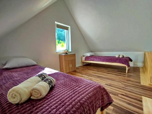 ein Schlafzimmer mit einem lila Bett und einem Fenster in der Unterkunft Lawendowy Klimat in Bóbrka