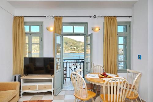 een woonkamer met een tafel en een televisie bij Faros Coastal Apartments in Skopelos Town