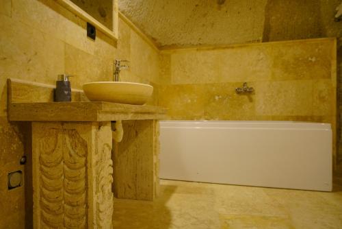 a bathroom with a sink and a bath tub at Vezir Cave Suites in Goreme