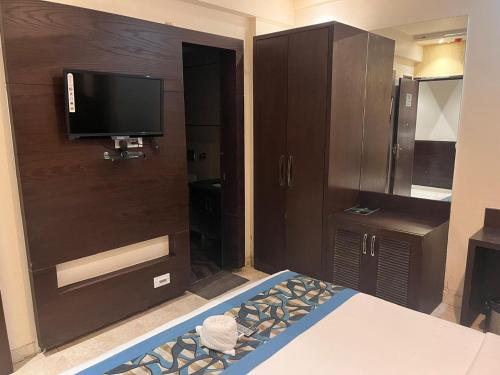 um quarto com uma cama e uma televisão na parede em HOTEL JODHA THE GREAT em Agra