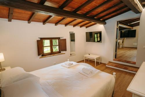 a bedroom with a large white bed in a room at Borgo Il Poggiaccio Residenza d'Epoca in Sovicille