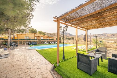 un patio al aire libre con piscina y pérgola en Cortijo El Pinar 1, en Níjar