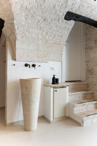 a kitchen with white counters and a stone ceiling at La Chianca, Farinella - Suits & Apartments in Putignano