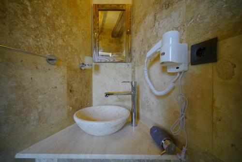 a bathroom with a sink with a bowl on the counter at Vezir Cave Suites in Goreme