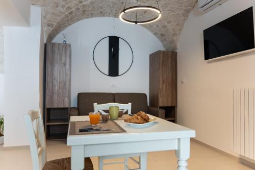 een eetkamer met een witte tafel met eten erop bij La Chianca, Farinella - Suits & Apartments in Putignano
