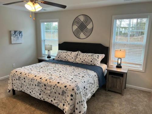 a bedroom with a bed and two windows and a fan at Belvedere in Anderson