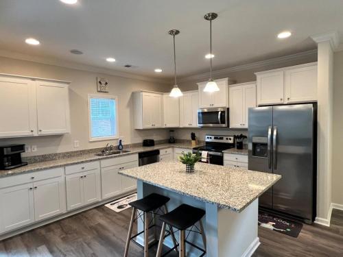a kitchen with white cabinets and a island with bar stools at Belvedere in Anderson