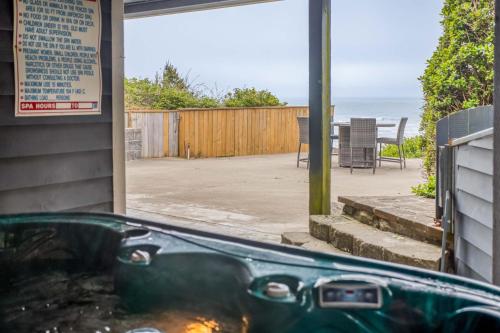 a hot tub in front of a house with a patio at Beauty On The Beach in Depoe Bay