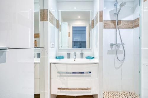 une salle de bain blanche avec un lavabo et une douche dans l'établissement Le Marignan, à Cannes
