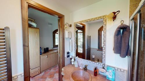 bagno con lavandino e grande specchio di Etna Bungalow - Adriana a Maletto