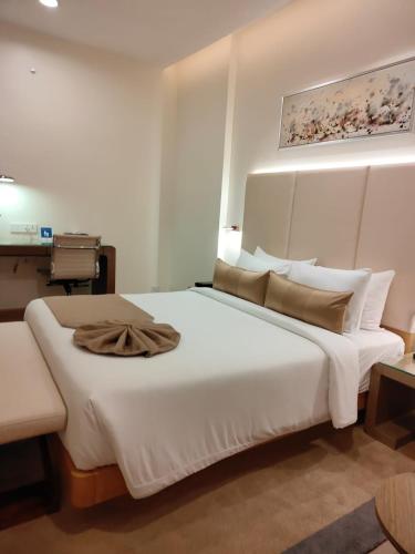 a bedroom with a large white bed with a painting on the wall at Fortune Hosur - Member ITC Hotels' Group in Hosūr