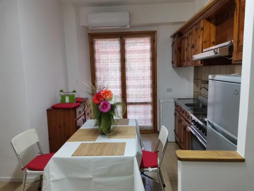a kitchen with a table with a vase of flowers on it at Appartamento climatizzato Alechome in Tagliacozzo