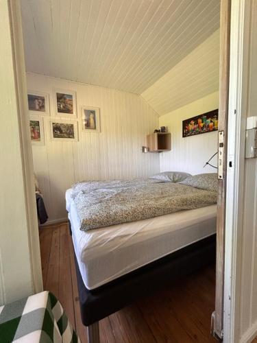 ein Schlafzimmer mit einem Bett in einem Zimmer in der Unterkunft Strandhytten in Køge