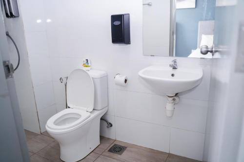 a white bathroom with a toilet and a sink at KLIA AIRPORT HOMESTAY 2 in Sepang