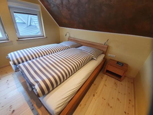 a large bed in a small room with a window at TinyHausDorf Wendland in Gartow