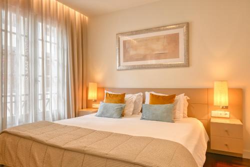 a bedroom with a large bed and a window at Colombo Square, a Home in Madeira in Funchal