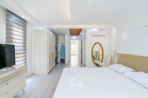 una camera bianca con letto e TV di Luxury villa Ada Marin a Kusadası