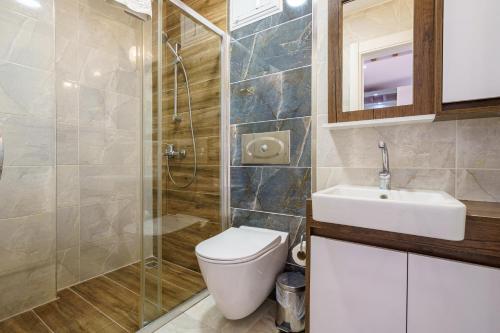 a bathroom with a toilet and a sink and a shower at Luxury villa Ada Marin in Kusadası