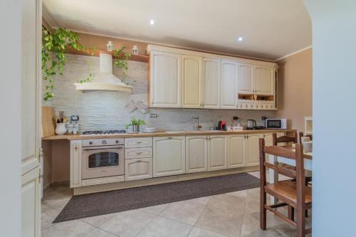 a kitchen with white cabinets and a stove at La casa di Lola in Monterosi