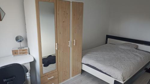- une chambre avec un lit, une armoire et un bureau dans l'établissement Maison mes délices, à Caen