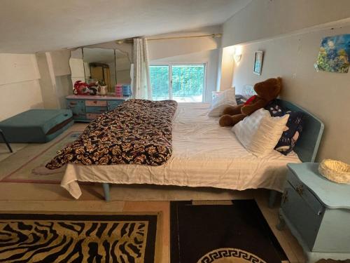 a bedroom with a large bed with a teddy bear on it at Misty Mountain in Murree