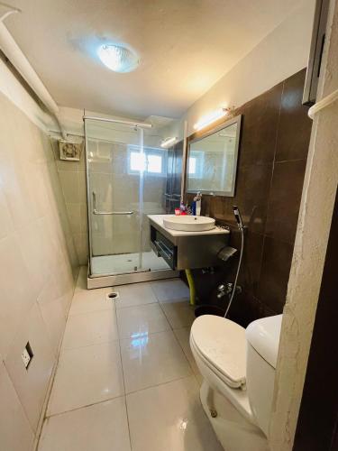 a bathroom with a toilet and a sink and a shower at Misty Mountain in Murree