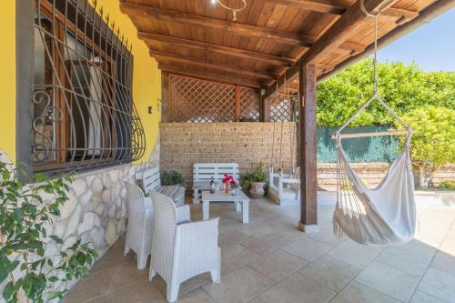 a patio with a hammock and a table and chairs at La casa di Lola in Monterosi